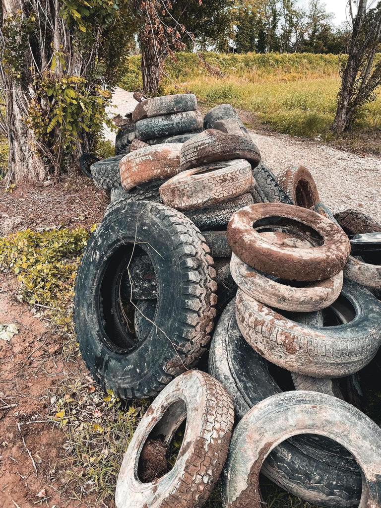 A collection of discarded tires resting on the ground