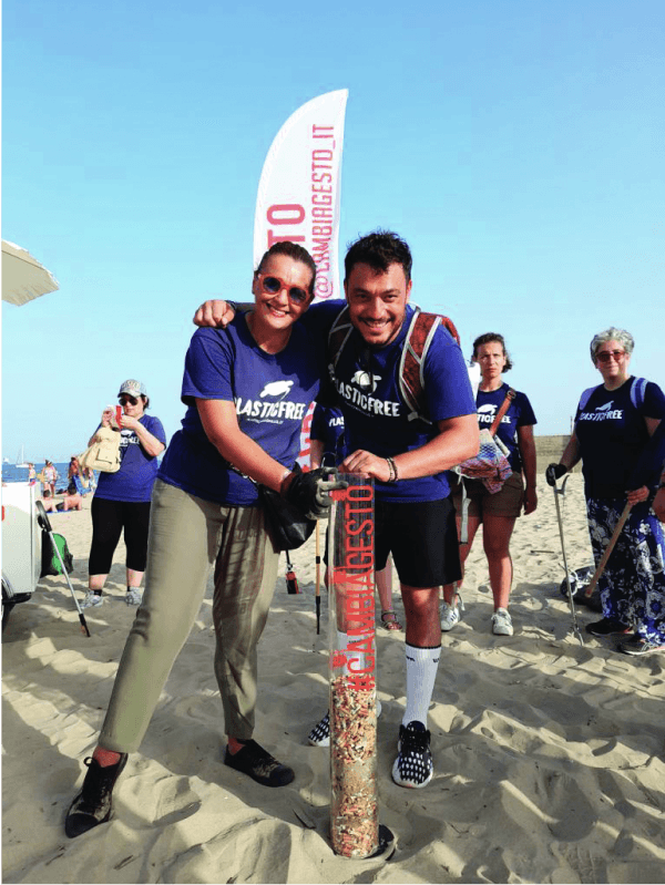 Un gruppo di volontari plastic free che mostra le sigarette raccolte in una spiaggia